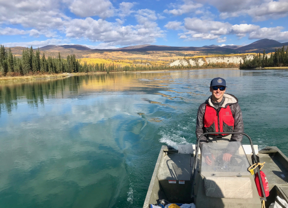 A small motorized boat being piloted on a lake