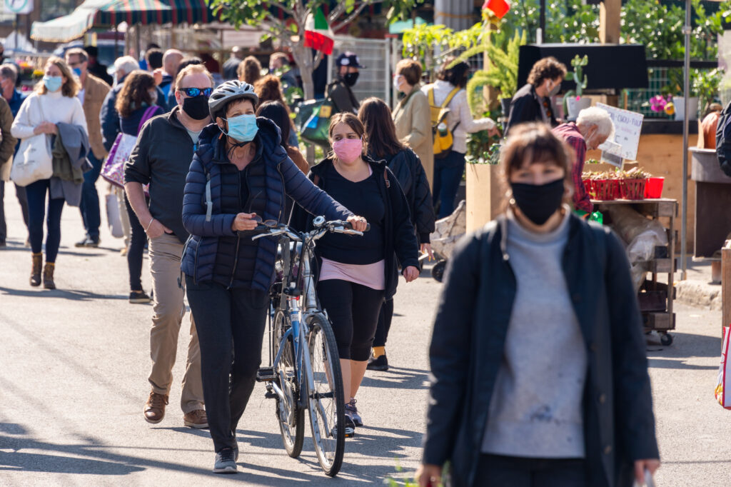 A busy city sidewalk with everyone wearing a face mask 