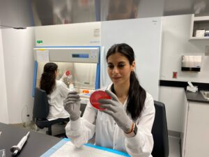 Woman in lab examining a petri dish